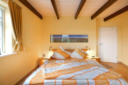 a bedroom with a large bed with pillows at Fewo Nordermühle in Pellworm