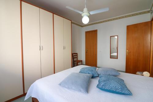 a bedroom with a bed with blue pillows on it at Elegante "casa Karm" 6 posti in Otranto