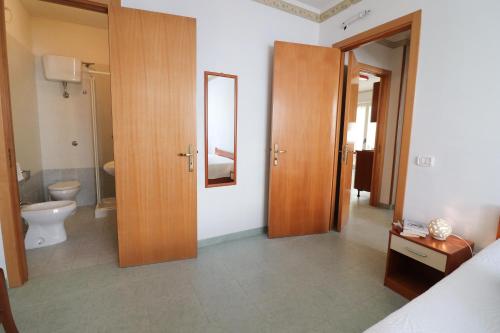 a bedroom with a bathroom with a toilet and a mirror at Elegante "casa Karm" 6 posti in Otranto