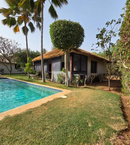 a villa with a swimming pool and a house at Jardin d'Afrique, Saly in Saly Portudal