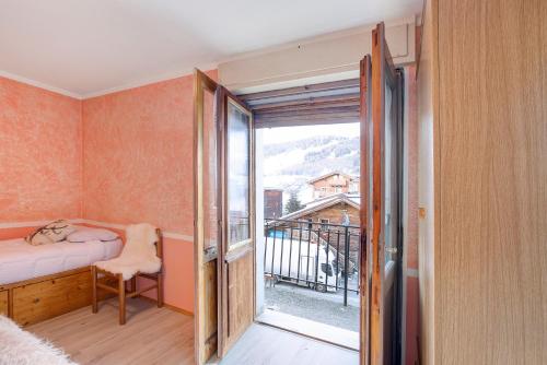 a bedroom with a door open to a balcony at Lovin Winter in Livigno