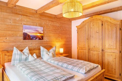 a bedroom with a bed and a wooden wall at Ferienwohnung Höllental in Grainau