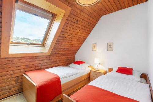 two beds in a room with a window at Haus Barbara in Bernau im Schwarzwald