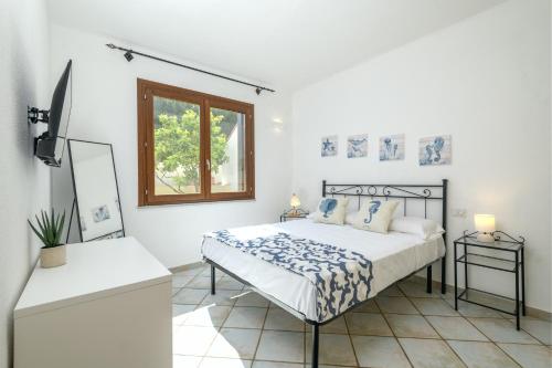 a white bedroom with a bed and a window at Lazulite - Sardinia Suite in Murta Maria