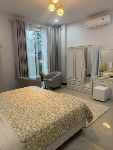 a bedroom with a large bed and a mirror at Aroyapoolvilla69 in Ban Yep Chaeng