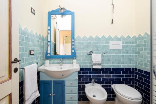 a blue tiled bathroom with a sink and a toilet at Casa Sole in Dorgali