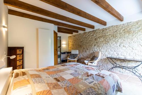 a bedroom with a stone wall and a bed at Chambre Millepertuis in Auriac-du-Périgord
