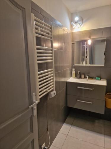 a bathroom with a sink and a mirror at Gite l'Embellido in Mouriès