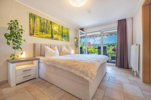 a bedroom with a large bed and a large window at Ferienwohnung Fasse in Uslar
