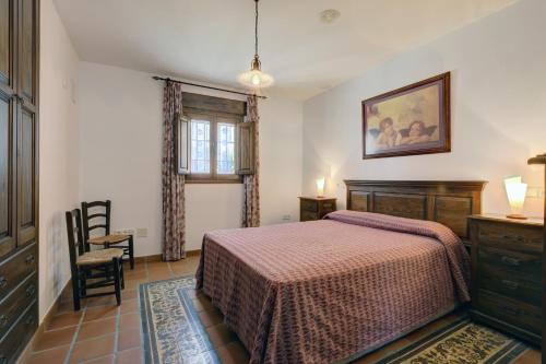 a bedroom with a bed and a table and a window at Casa Jimena 2 personas in Jimena de la Frontera
