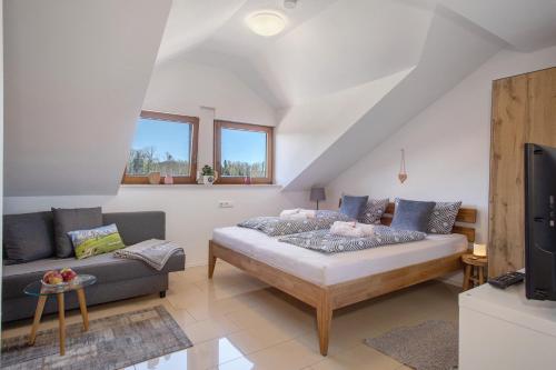 a living room with a bed and a couch at Bergchalet Mirabell - Hofgut in Friedrichshafen