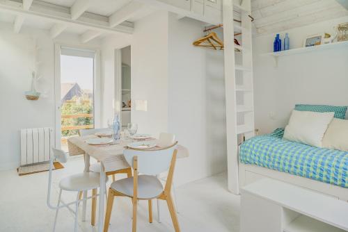 a white room with a table and chairs and a bed at La Cabane des Goélands Rieurs in Dinard