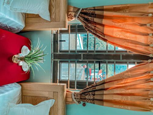 a room with a window with a curtain and pillows at Sơn Tùng Hostel in Cat Ba