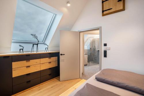 a bedroom with a sink and a window at Waldlux Luxus-Chalet Brennhus in Kappelrodeck