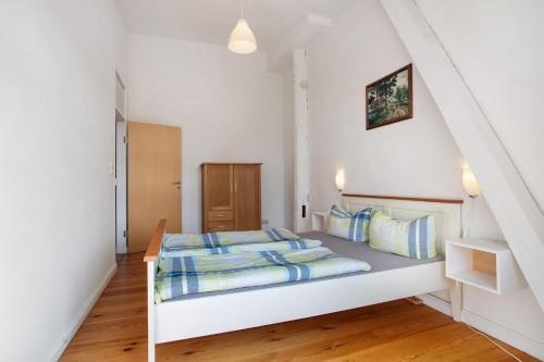 a bedroom with a white bed with blue pillows at Alte Seifensiederei - Ferienloft in Stralsund