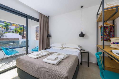 a bedroom with two beds and a desk with towels at Lambis Athina in Lindos