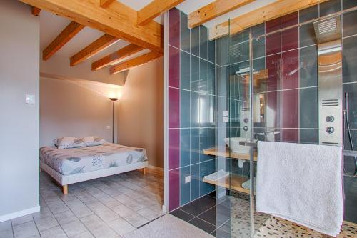 a bedroom with a bed and a bathroom with a shower at Gîte Ludomi in Vercheny