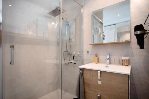 a bathroom with a shower with a sink and a mirror at Sea view - dream Nazaré in Nazaré