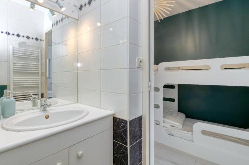 a white bathroom with a sink and a mirror at Appartement front de mer - Terrasse in Pornichet