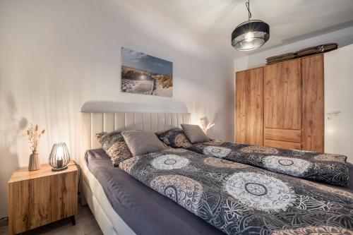 a bedroom with a bed and a wooden cabinet at Fewo Seehase in Dorum-Neufeld