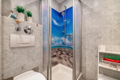 a bathroom with a shower with a mural of a beach at Fewo Seehase in Dorum-Neufeld