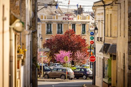 a city street with cars parked on the street at Logis Hotel De France in La Chartre-sur-le-Loir