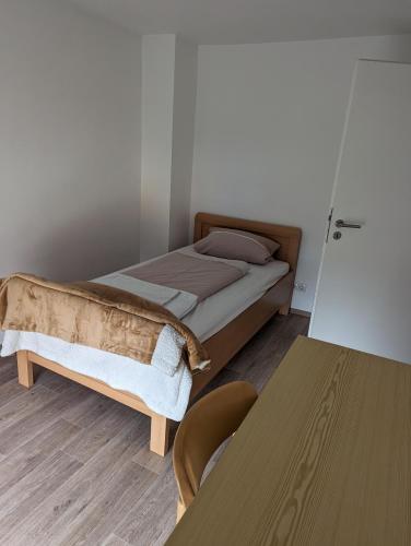 a small bedroom with a bed and a table at Ferienwohnung Beck in Ansbach