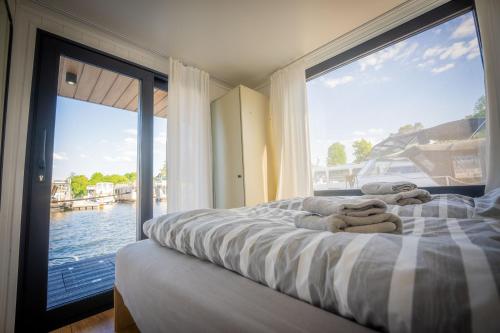 a bedroom with a bed with a view of the water at Exklusives Hausboot Pina Woma D13 in Fürstenberg