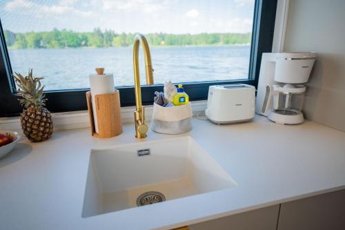 a kitchen counter with a sink and a window at Exklusives Hausboot Pina Woma D13 in Fürstenberg