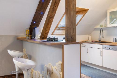 a kitchen with white cabinets and wooden beams at Ferienwohnung Schiller in Grebenhain