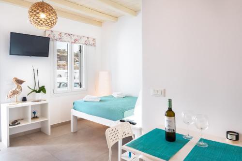 a bedroom with a bed and a table with a bottle of wine at Irene's Studio in Mikonos