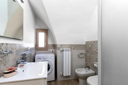 a bathroom with a sink and a washing machine at Casa vacanza Sotto La Lizza in Alezio