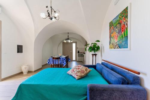 a blue bed in a room with a blue couch at Casa vacanza Sotto La Lizza in Alezio