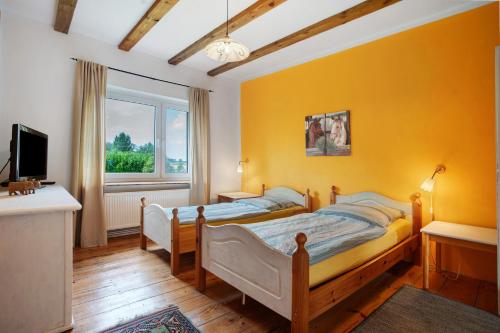 a bedroom with two beds and a yellow wall at Fereienhaus Usedom Achterland in Dewichow