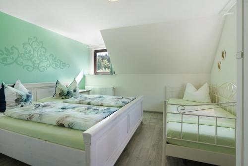 a white bedroom with a bed and a window at Ferienhaus Pöhlbergblick Schindelba in Großrückerswalde