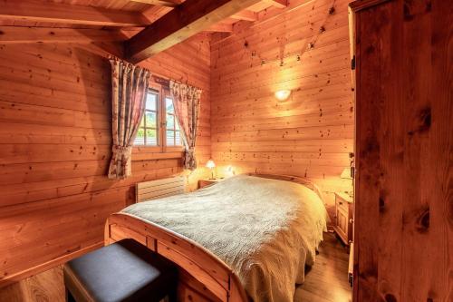 a bedroom with a bed in a log cabin at Chalet mitoyen 4 personnes in Alex