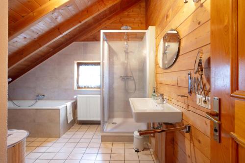 a bathroom with a shower and a sink and a tub at Ferienhaus Sankt Peter in Wittenschwand