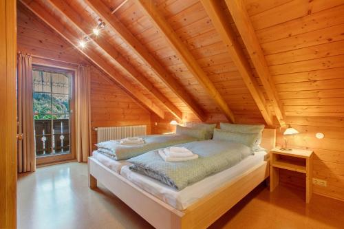 a bedroom with a bed in a wooden house at Ferienhaus Sankt Peter in Wittenschwand