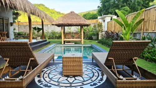 a pool with two chairs and a gazebo at Amed Saïta Villas in Amed