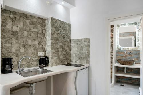 a white kitchen with a sink and a counter at Politimis Studio N5 in Amorgos