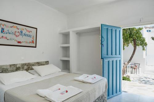 a bedroom with two beds and a blue door at Politimis Studio N5 in Amorgos