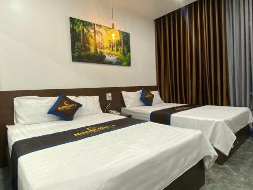 a hotel room with two beds and a window at Moonknight 2Hotel in Sầm Sơn