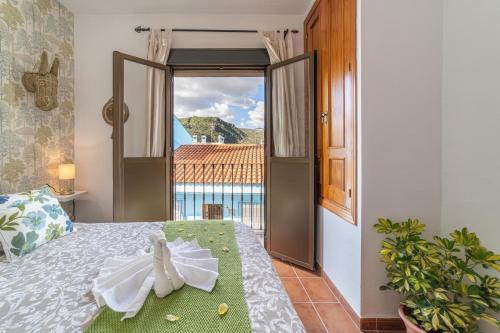 a bedroom with a bed with a view of the ocean at La Casa Del Bosque in Júzcar