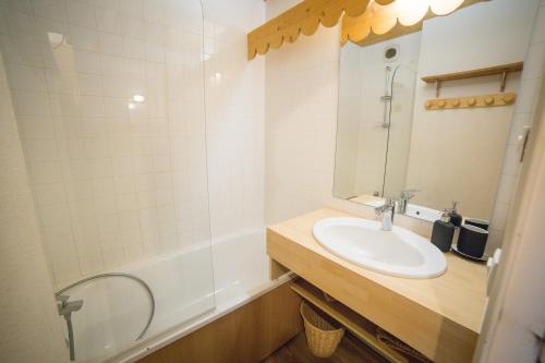 a bathroom with a sink and a shower and a mirror at Appartemment 6 couchages Risoul in Risoul