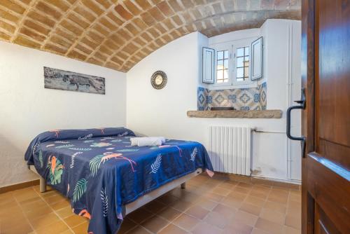 a bedroom with a bed with a blue blanket at Can Tarana in Santa Cristina d'Aro