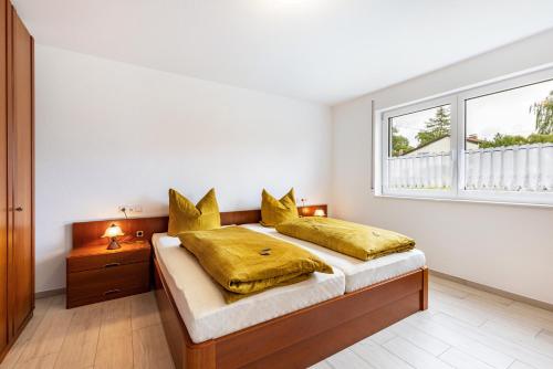 a bedroom with a bed with yellow pillows and a window at Ferienwohnung "Haus Kellenburg" in Albstadt