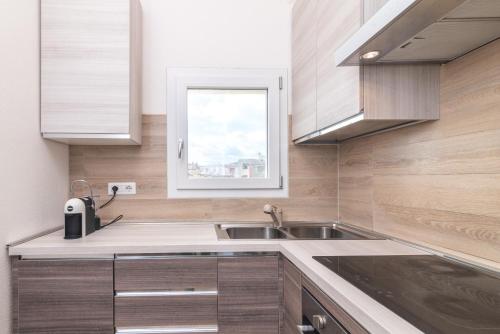 a kitchen with a sink and a window at Attico con vista mare a Budoni in Budoni
