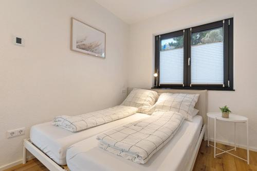 two beds in a room with a window at Meerrettichnest in Appenweier