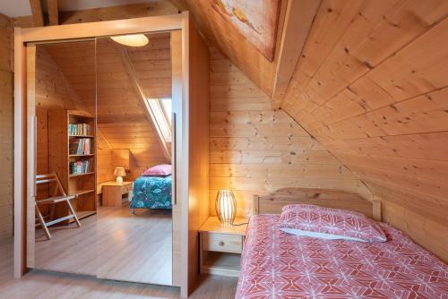ein Schlafzimmer mit einem Bett in einem Holzhaus in der Unterkunft Maison Zen dans les Pyrénées in Coarraze