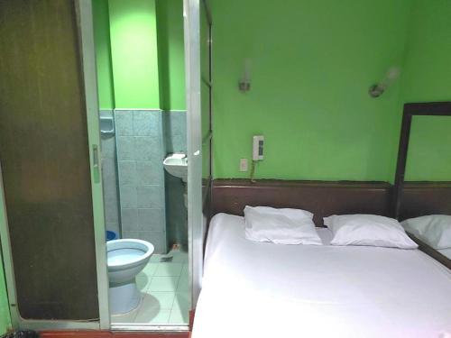 a bedroom with a bed and a bathroom with a toilet at MCT Hotel in Manila